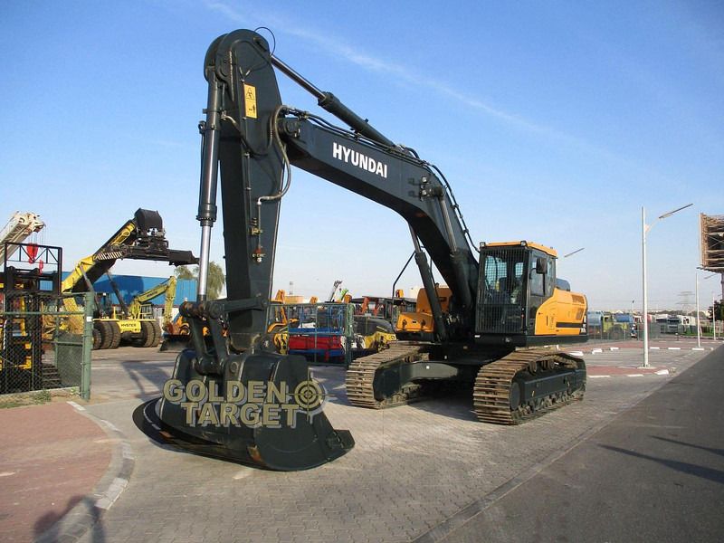 2023 Hyundai HX360L Crawler Excavator with a black boom and arm extended forward, showcasing the heavy-duty bucket. 2023 Hyundai HX360L Crawler Excavator with a black boom and arm extended forward, showcasing the heavy-duty bucket.