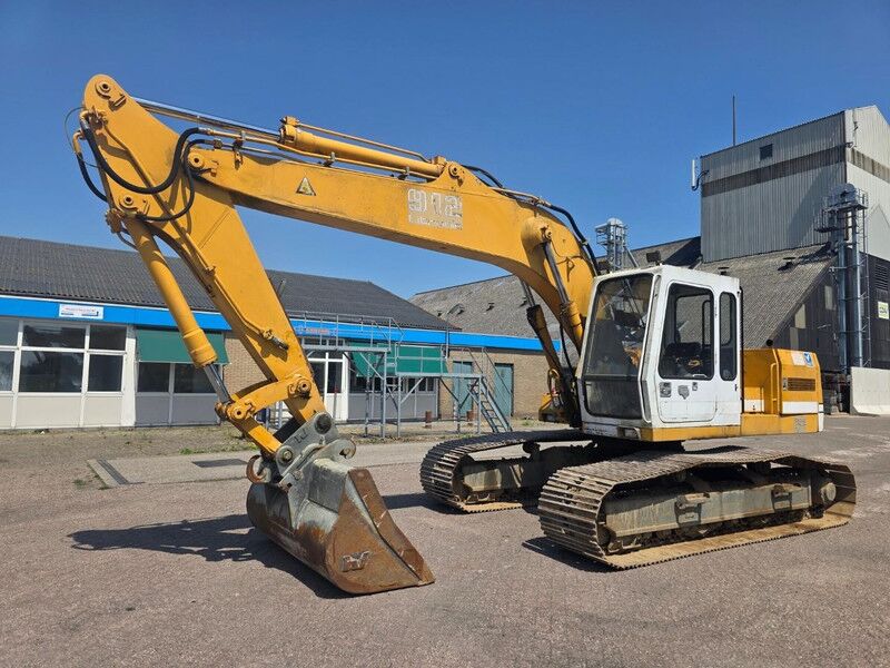 1991 Liebherr R 912 LC crawler excavator with yellow boom raised and toothless grading bucket lowered 1991 Liebherr R 912 LC crawler excavator with yellow boom raised and toothless grading bucket lowered