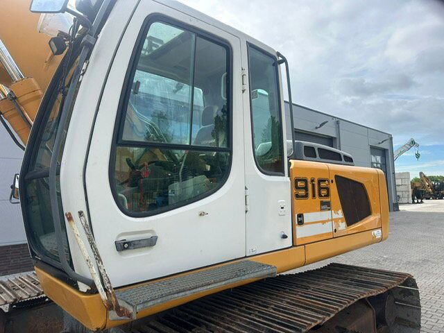 2010 Liebherr R 916 crawler excavator cab close-up showing the operator station, glazing and access step