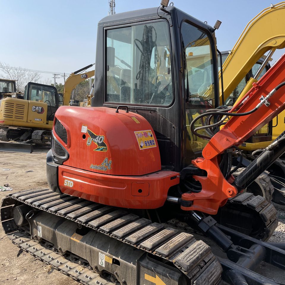 2026 Kubota U40-3 Mini Excavator with a close-up view of the operator's cab and engine cover showing U-40 decal. 2026 Kubota U40-3 Mini Excavator with a close-up view of the operator's cab and engine cover showing U-40 decal.